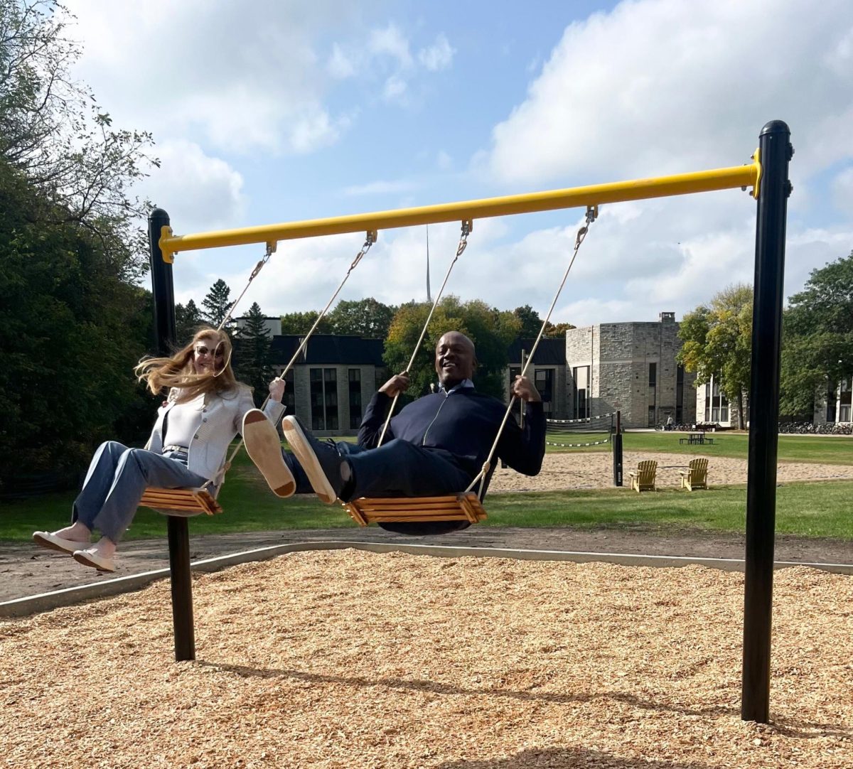 President Susan Rundell Singer and Vice President for Student Life Hassel  Morrison testing the swing set for the first time. 